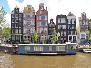 Amsterdam canal houses and house boat at Prinsengracht. Amsterdam Airport Private Layover Tour. Welcome to the "Gateway to Europe!" Private Tour Holland.